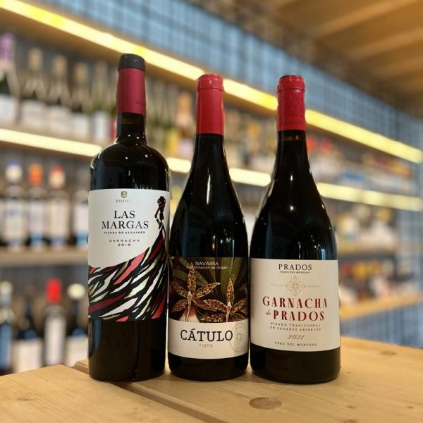 Imagen en la que aparecen los tres vinos del Club de Vinos Mayo 2023. De izquierda a derecha se encuentran: Las Margas Tinto, Cátulo Tinto y Prados Garnacha. Los tres son vinos tintos DO Navarra.
