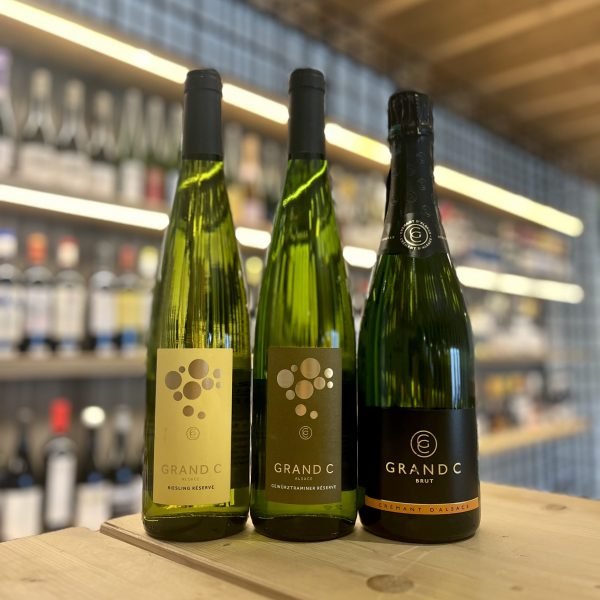 Imagen en la que aparecen los tres vinos del Club de Vinos Mayo 2023. De izquierda a derecha se sitúan dos vinos monovarietales y un vino espumoso. Grand C Riesling, Grand C Gewürztramimer y Grand C Cremant d'Alsacia rinden homenaje a la región de Alsace.